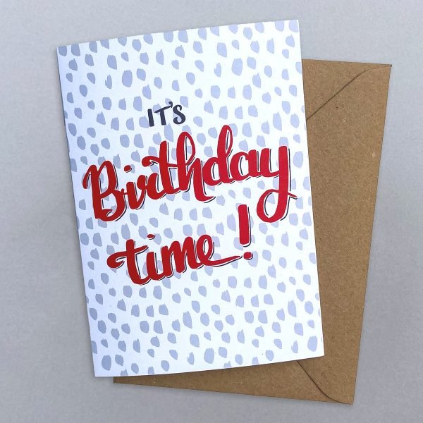 A hand drawn greeting card with It's Birthday time! in red on a light grey spotted background