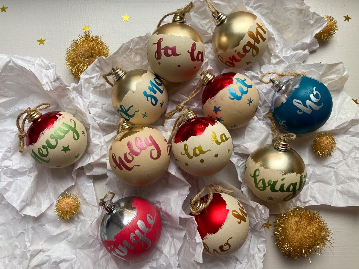 a range of hand lettered plastic Christmas baubles