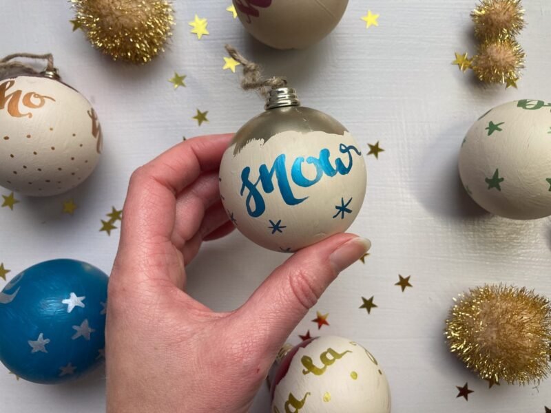 let it snow hand calligraphy bauble in blue and gold