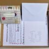 Kit contents shown as shipped in box - pack of metallic pens, template cards and envelopes, calligraphy worksheets