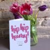 Hip hip hooray 5x7 birthday card next to a vase of tulips